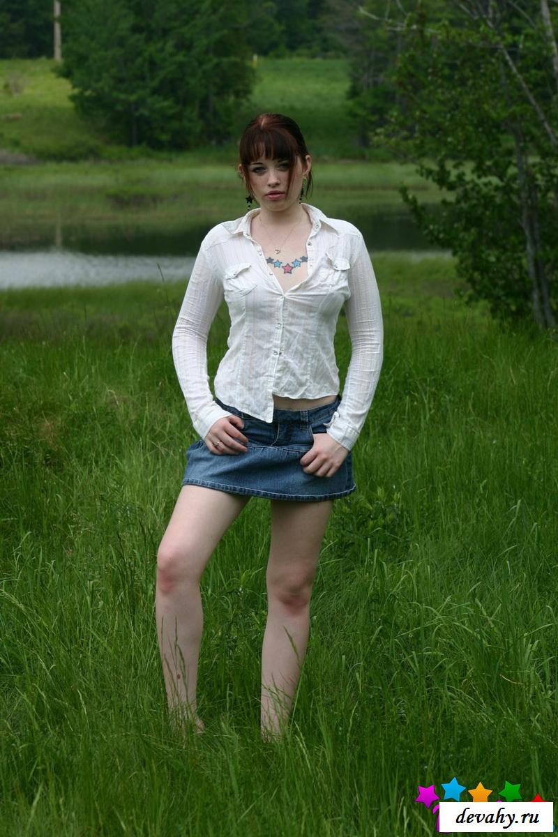 На фото голой молоденькой девушки на траве показала грудь